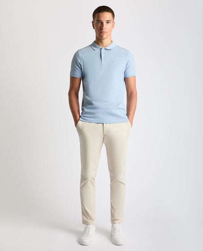 Man wearing a blue Tapered Fit Cotton Pique Polo Shirt