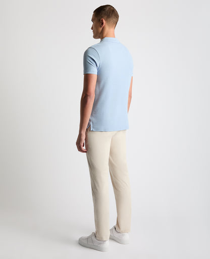Man wearing a blue Tapered Fit Cotton Pique Polo Shirt