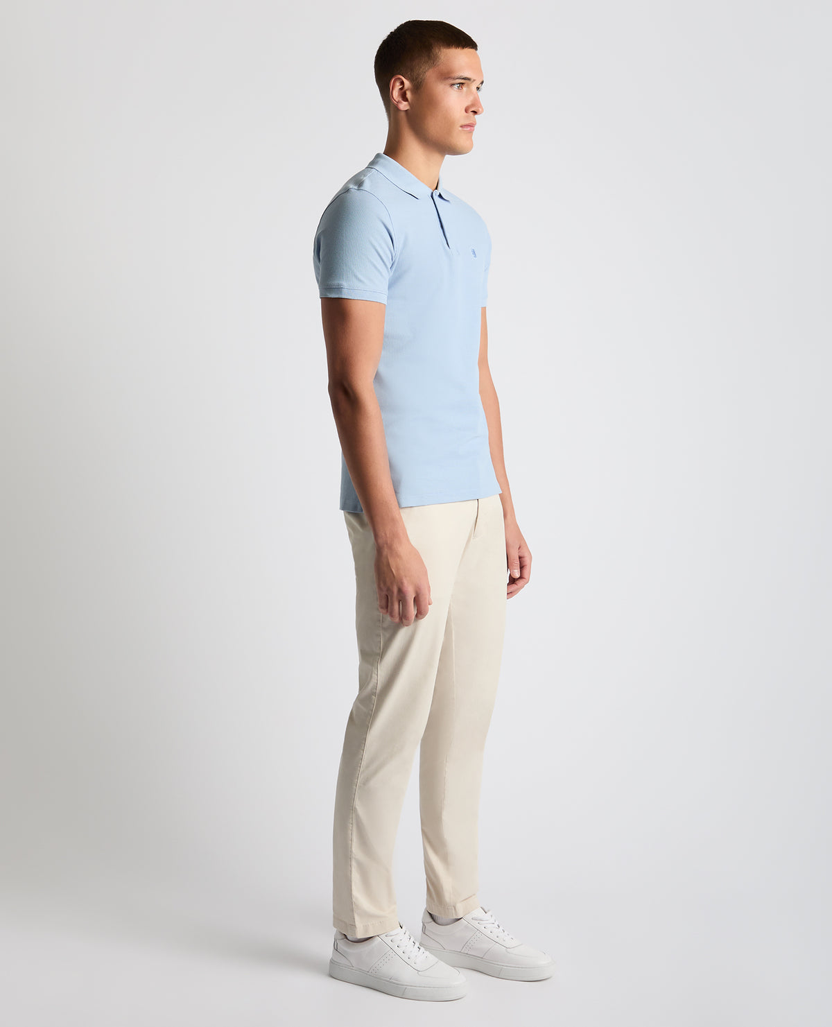 Man wearing a blue Tapered Fit Cotton Pique Polo Shirt