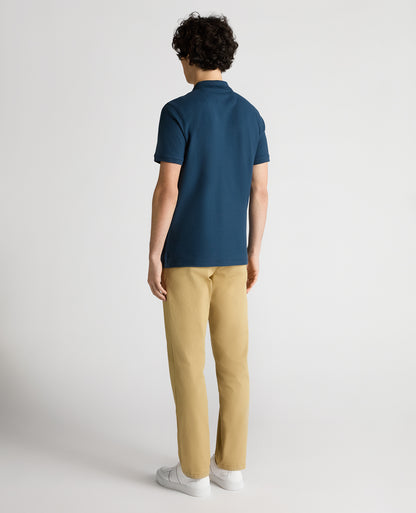 Man wearing a blue Tapered Fit Cotton Pique Polo Shirt