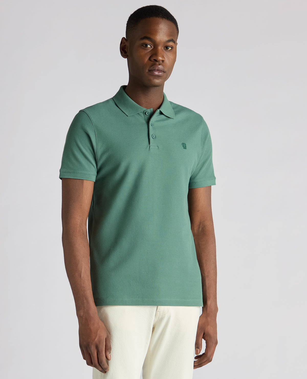 Man wearing a green Tapered Fit Cotton Pique Polo Shirt