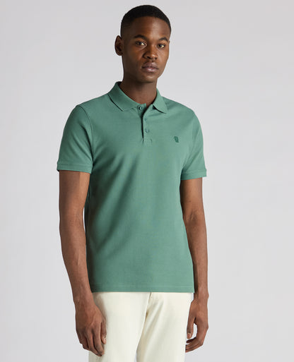 Man wearing a green Tapered Fit Cotton Pique Polo Shirt