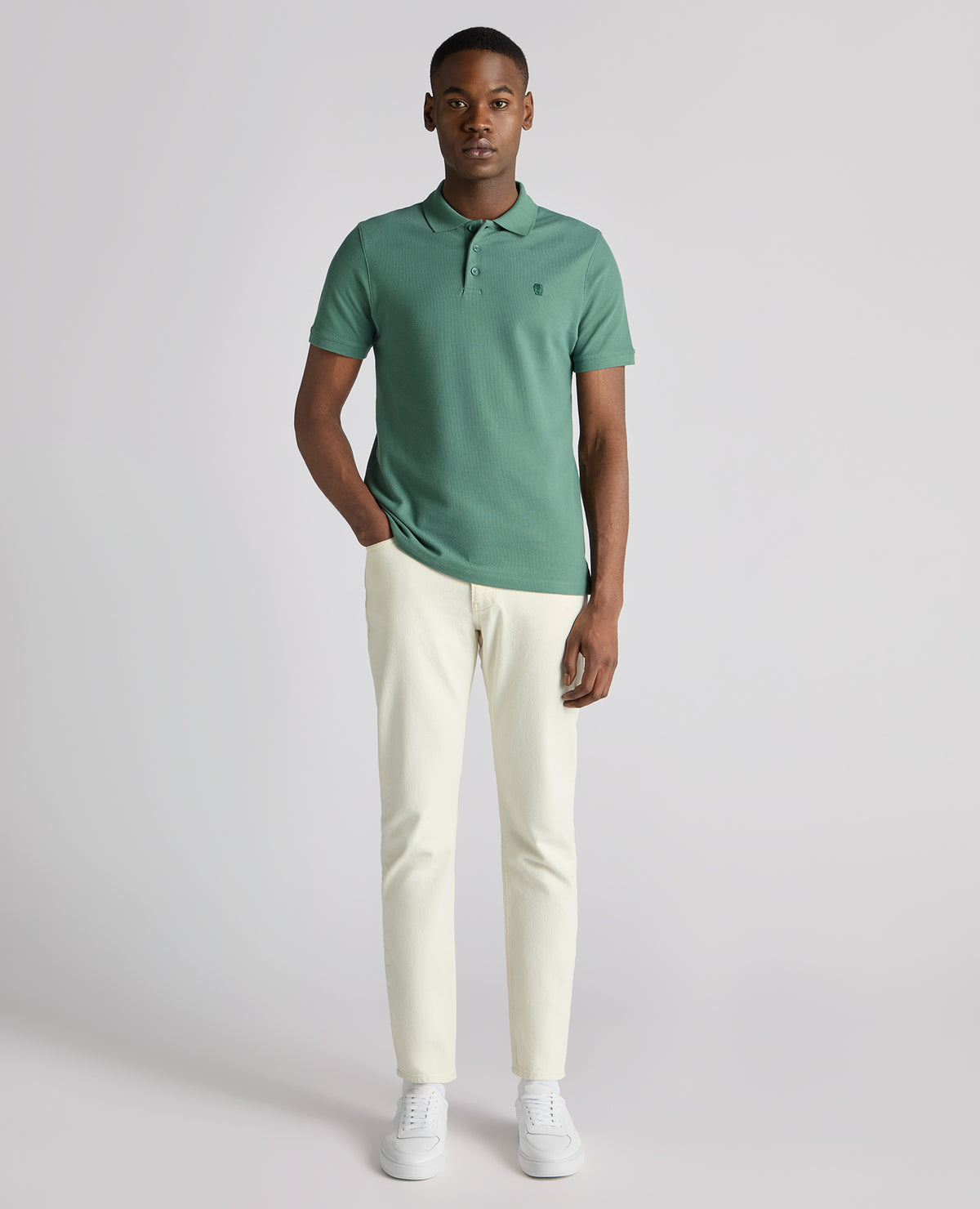 Man wearing a green Tapered Fit Cotton Pique Polo Shirt
