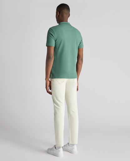 Man wearing a green Tapered Fit Cotton Pique Polo Shirt