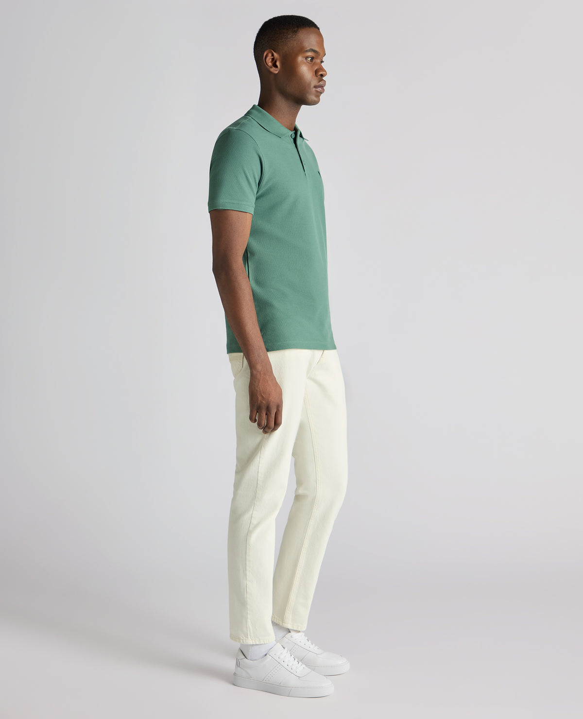 Man wearing a green Tapered Fit Cotton Pique Polo Shirt