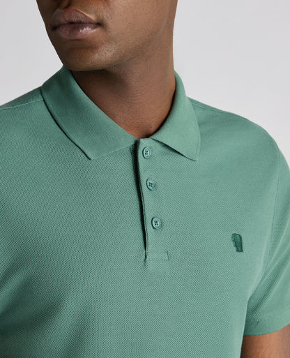 Man wearing a green Tapered Fit Cotton Pique Polo Shirt