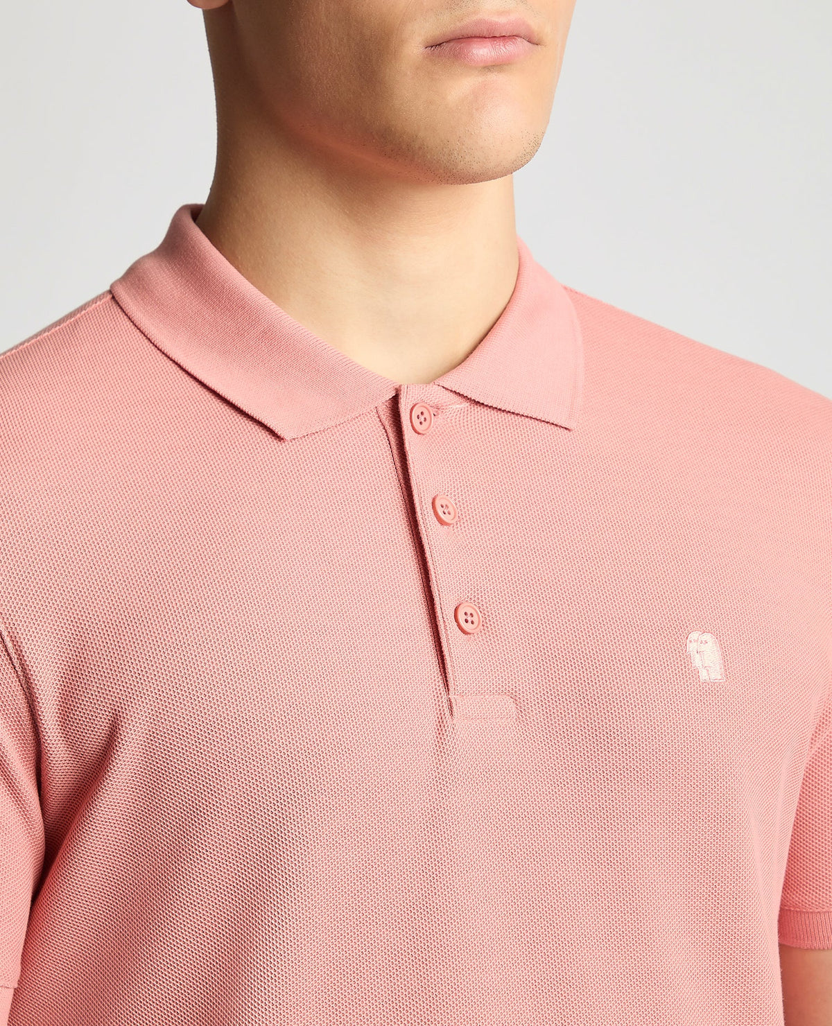 Man wearing a red Tapered Fit Cotton Pique Polo Shirt