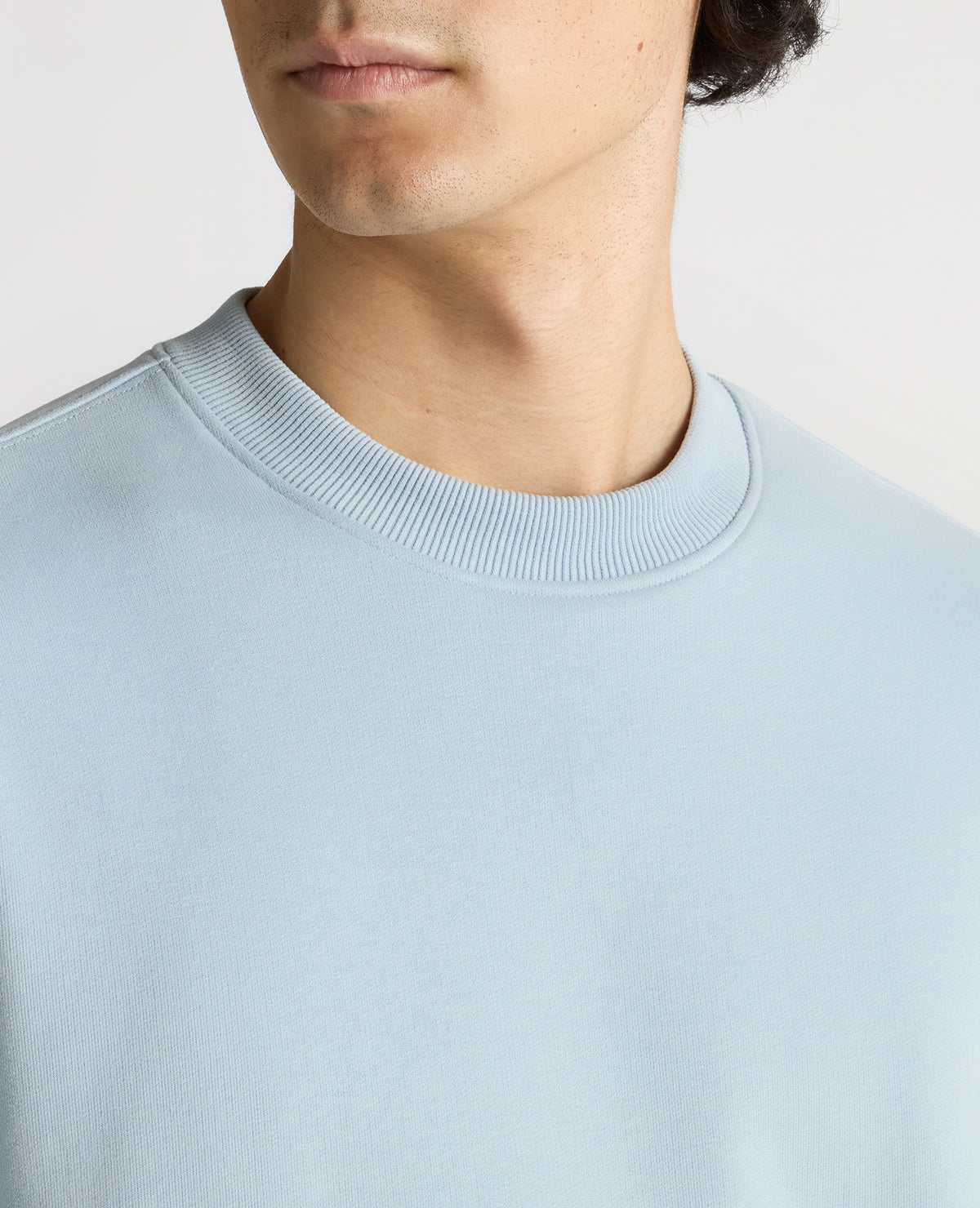 Man wearing a blue Tapered Fit Soft Touch Cotton-Blend Sweatshirt