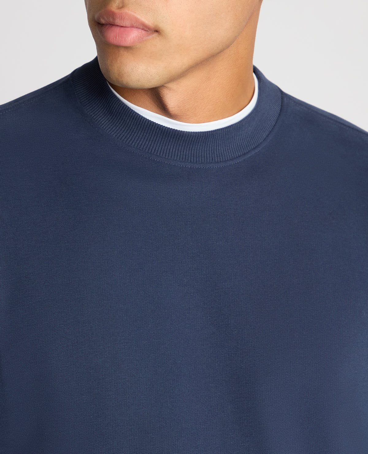 Man wearing a blue Tapered Fit Soft Touch Cotton-Blend Sweatshirt
