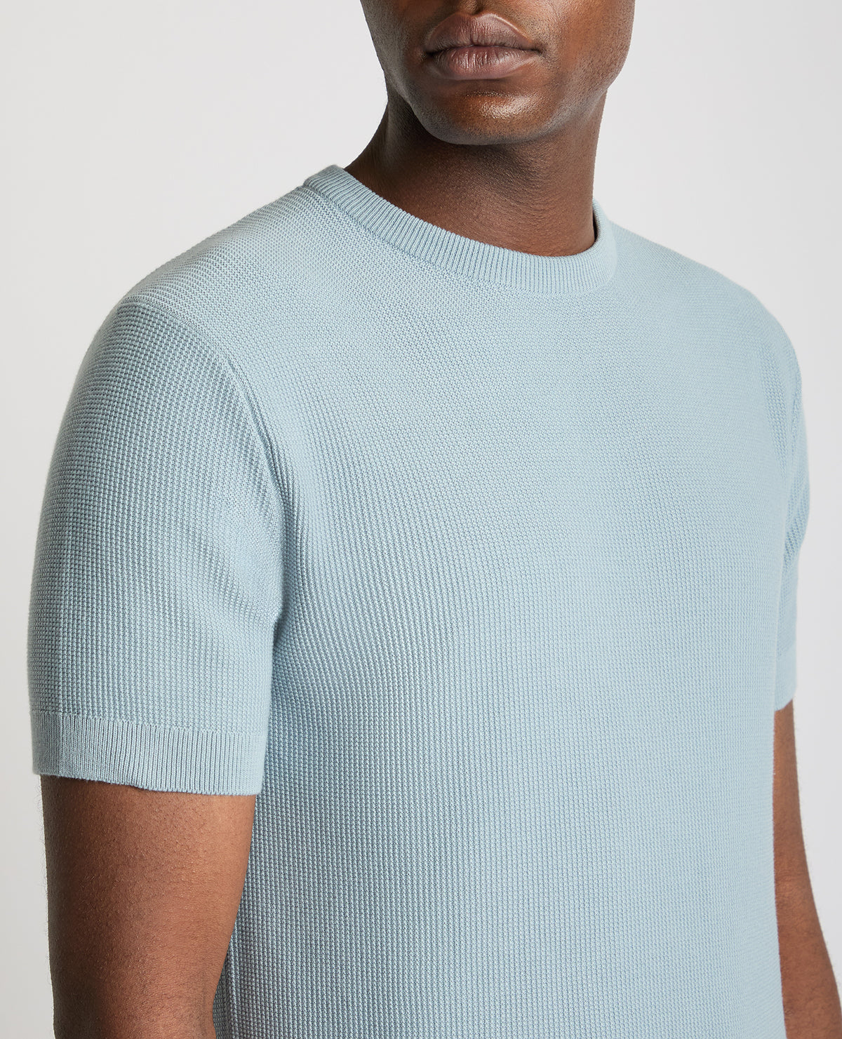 Man wearing a blue Slim Fit Wafffle Knitted Tee