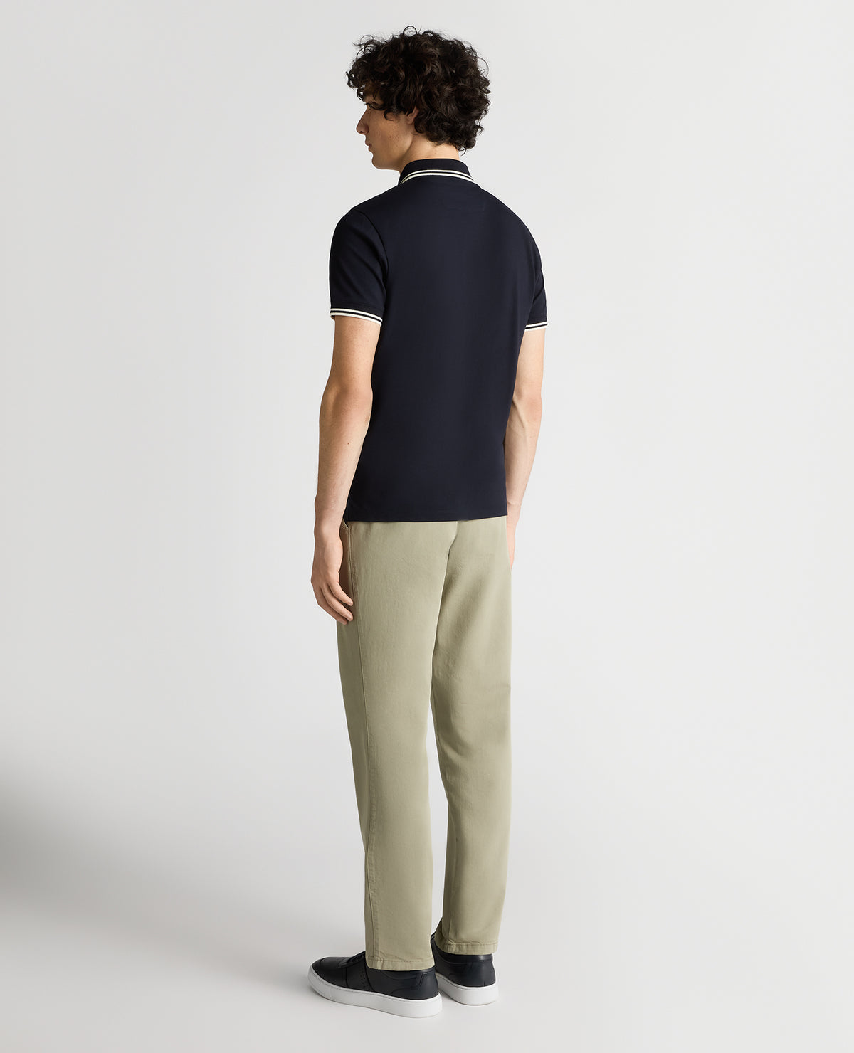 Man wearing a navy Tapered Fit Cotton-Stretch Polo Shirt