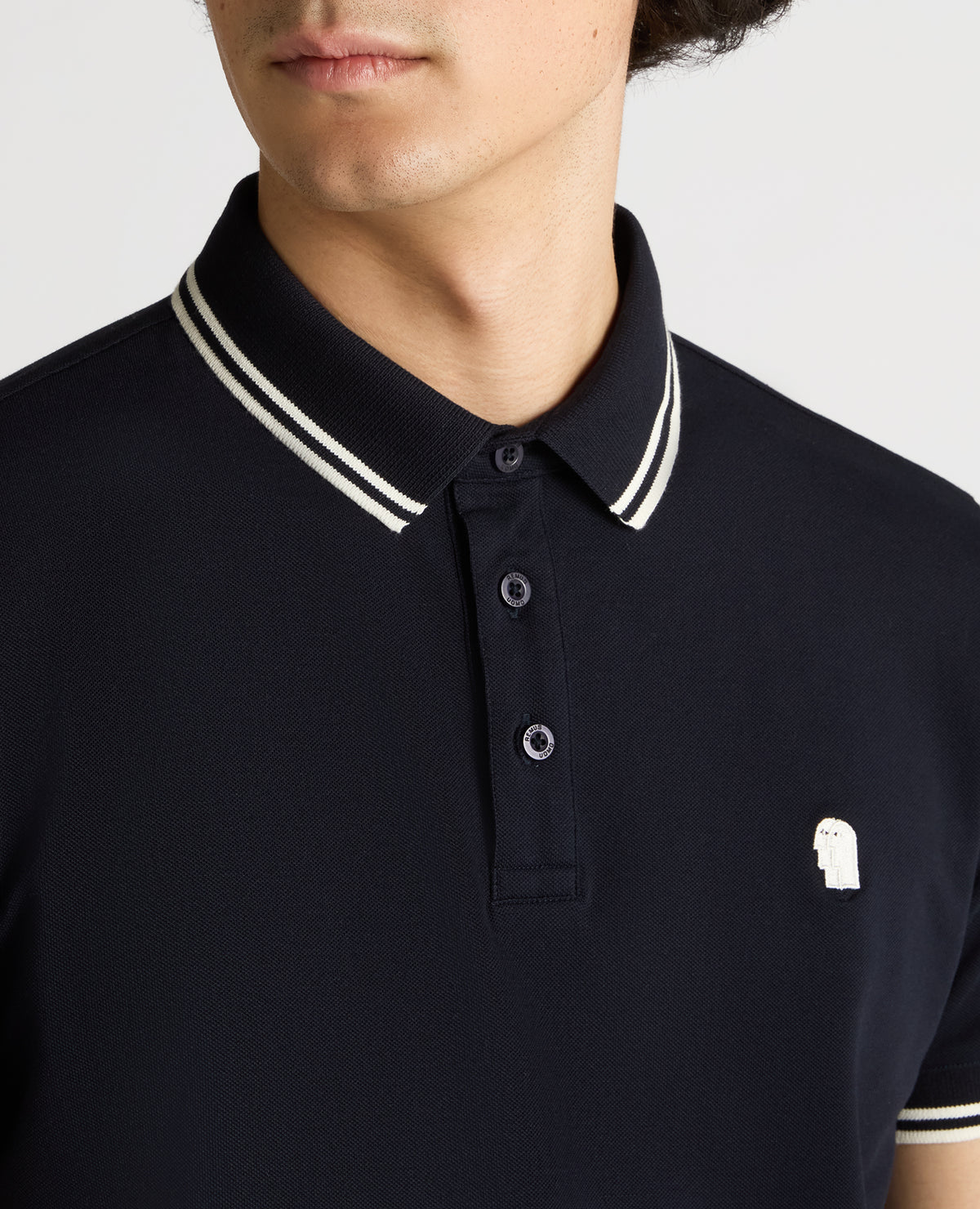 Man wearing a navy Tapered Fit Cotton-Stretch Polo Shirt