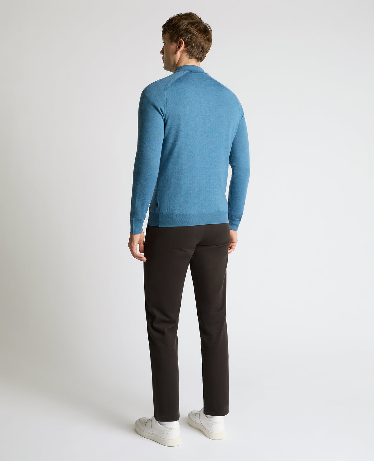 Man wearing a blue Merino Wool-Blend Knit Polo