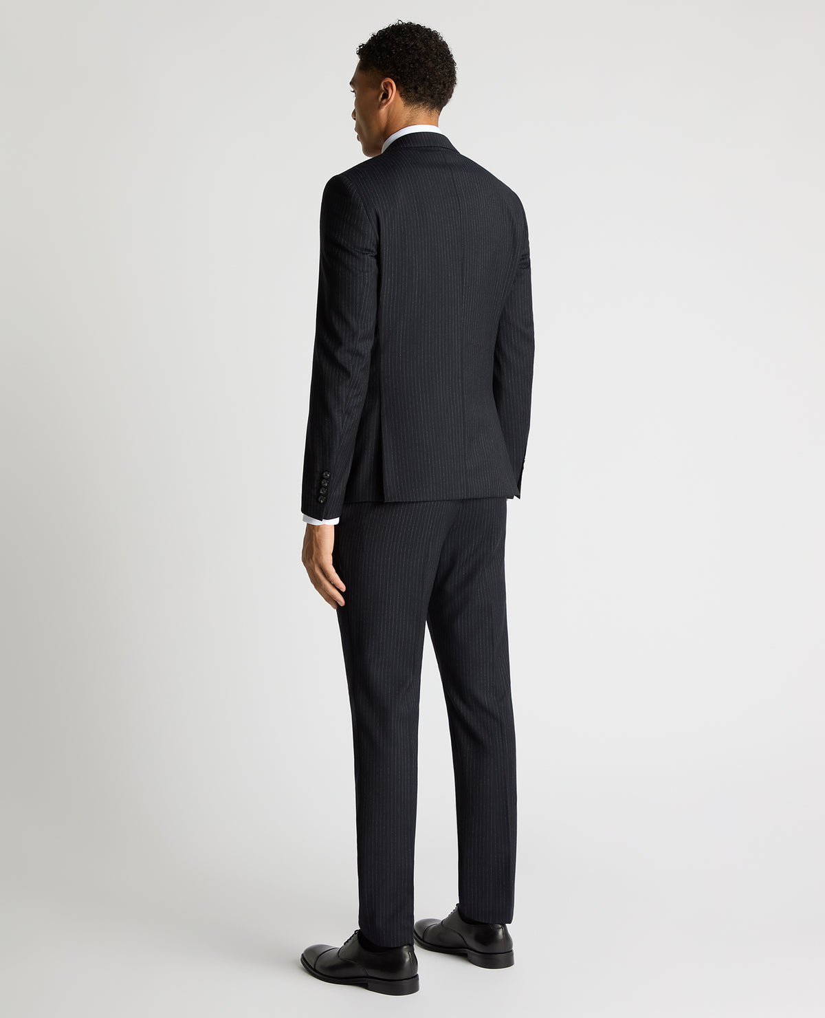 Man wearing a navy Slim Fit Pinstripe Wool Rich Suit