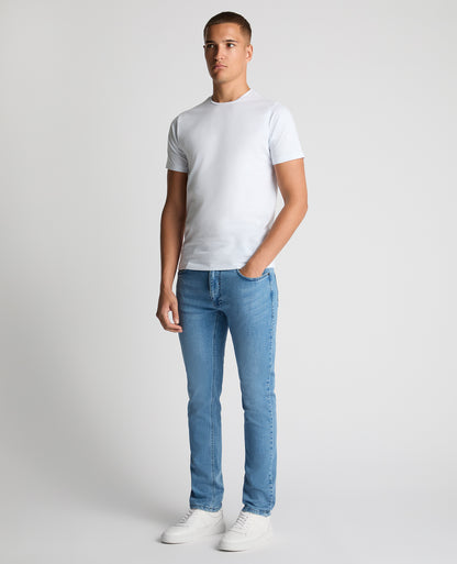 Man wearing a blue Apollo Slim Leg Cotton Power Stretch Jeans