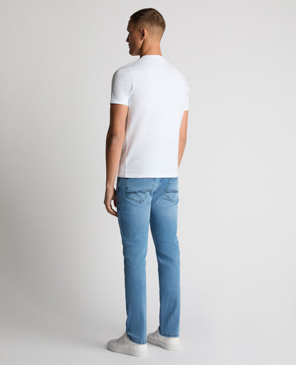 Man wearing a blue Apollo Slim Leg Cotton Power Stretch Jeans