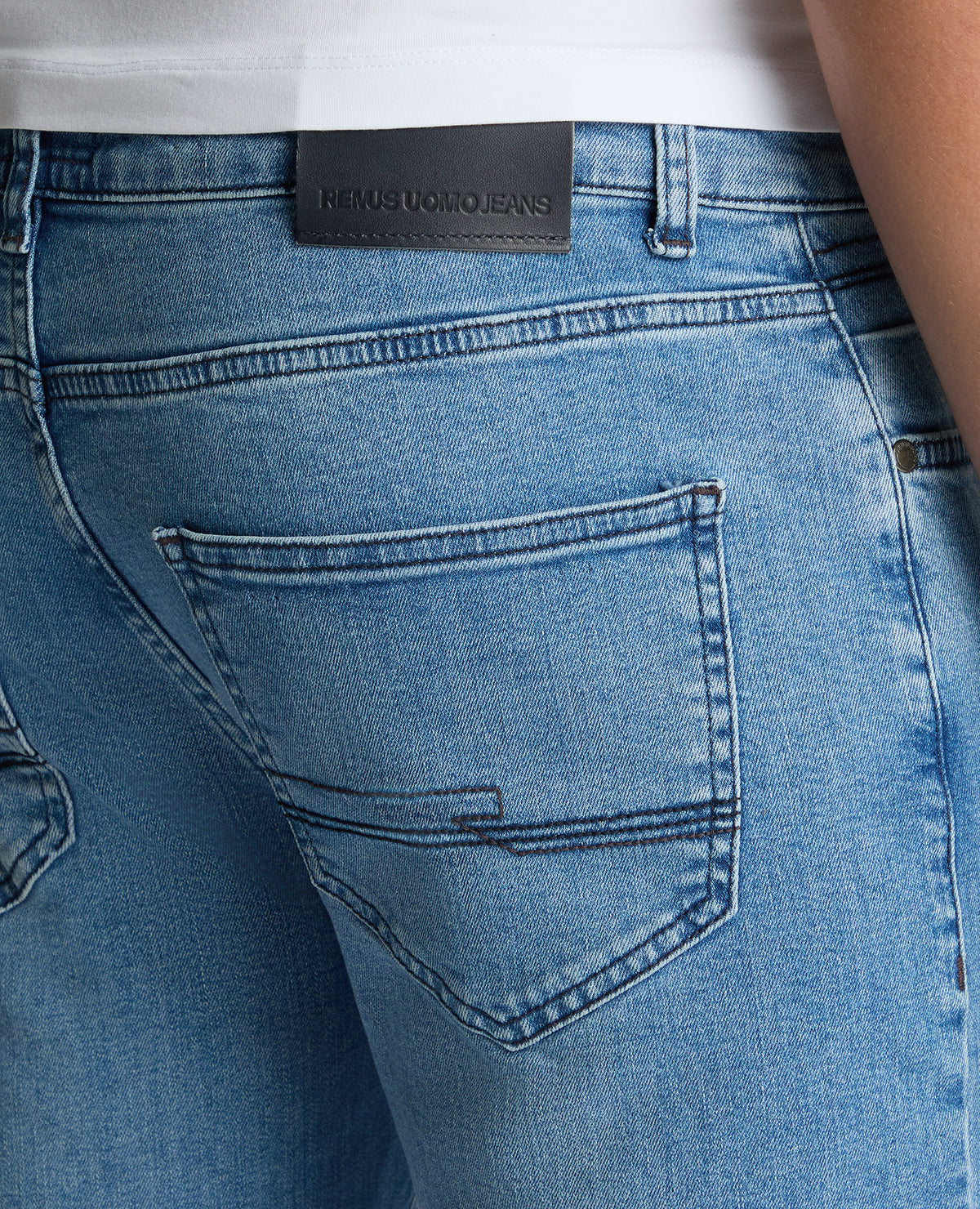 Man wearing a blue Apollo Slim Leg Cotton Power Stretch Jeans