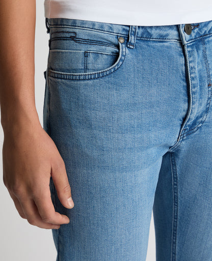 Man wearing a blue Apollo Slim Leg Cotton Power Stretch Jeans
