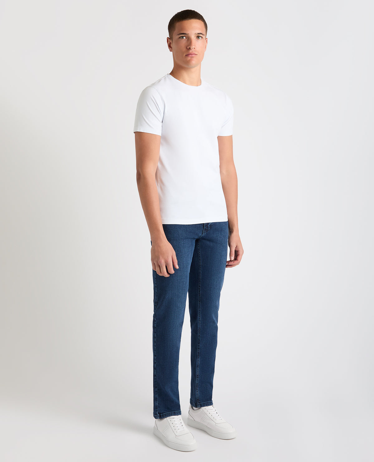 Man wearing a blue Apollo Slim Leg Cotton Power Stretch Jeans