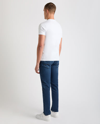Man wearing a blue Apollo Slim Leg Cotton Power Stretch Jeans