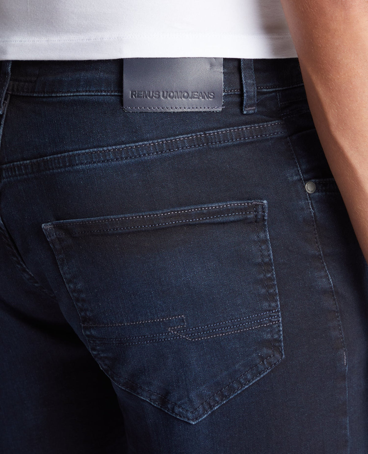 Man wearing a navy Apollo Slim Leg Cotton Power Stretch Jeans