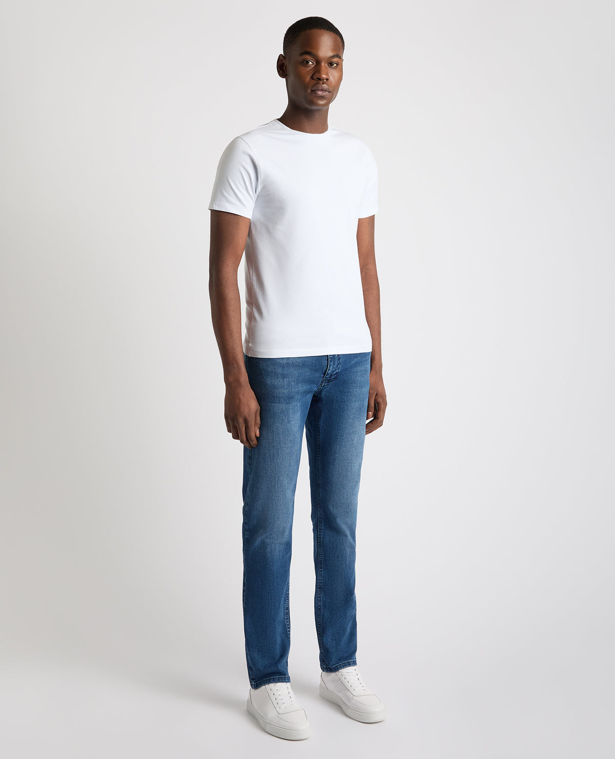 Man wearing a blue Rogan Straight Leg Eco Cotton-Stretch Jeans