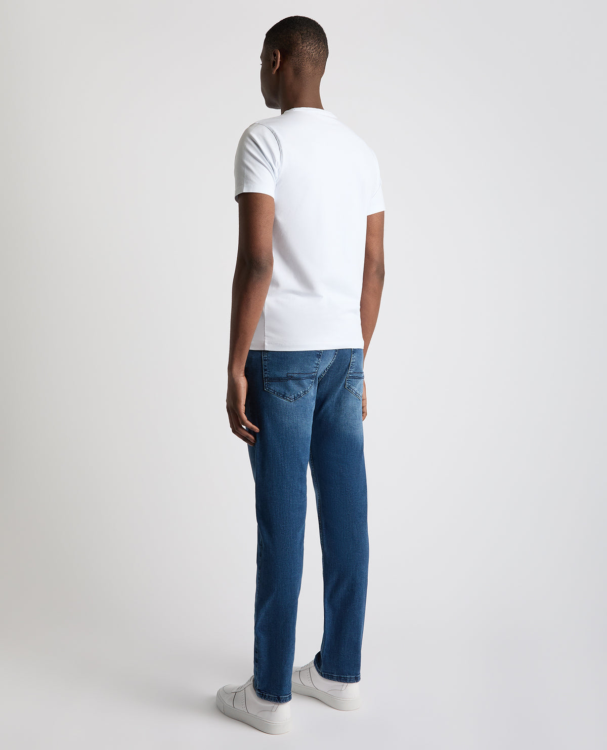 Man wearing a blue Rogan Straight Leg Eco Cotton-Stretch Jeans