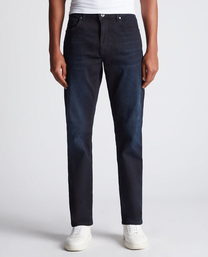 Man wearing a navy Rogan Straight Leg Eco Cotton-Stretch Jeans