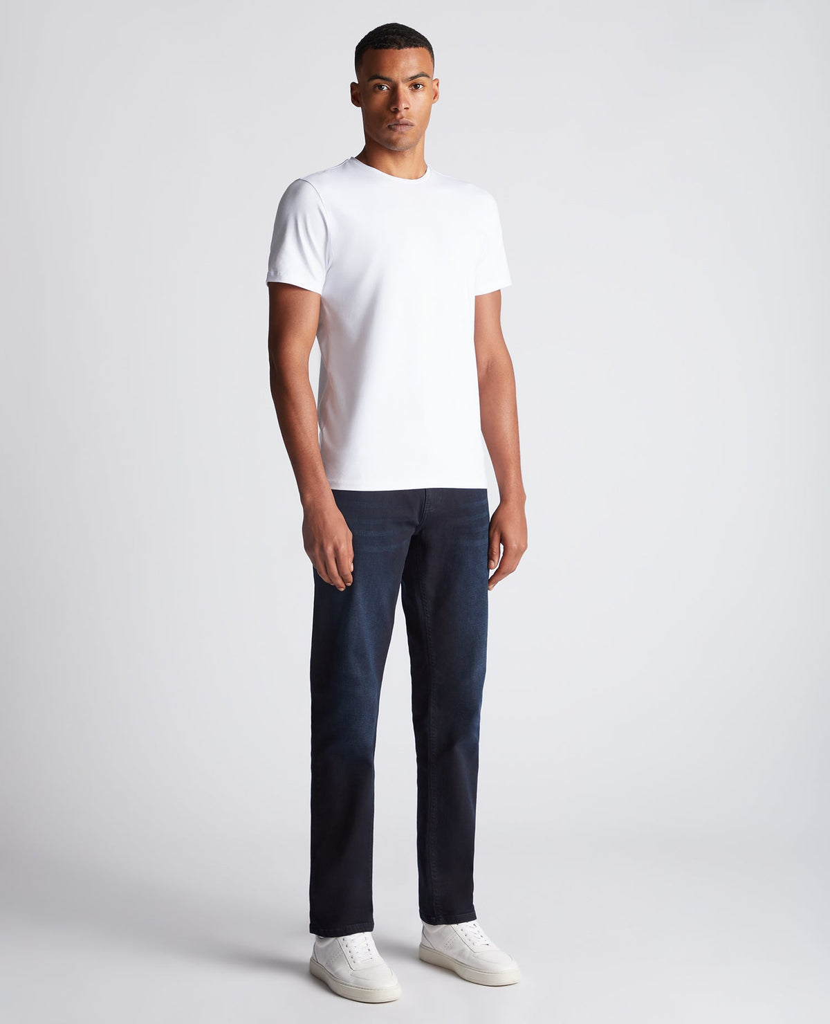 Man wearing a navy Rogan Straight Leg Eco Cotton-Stretch Jeans