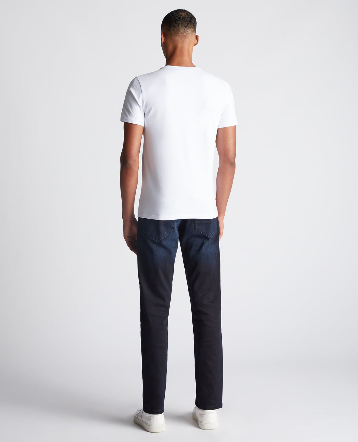 Man wearing a navy Rogan Straight Leg Eco Cotton-Stretch Jeans