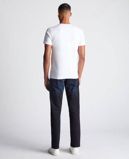 Man wearing a navy Rogan Straight Leg Eco Cotton-Stretch Jeans