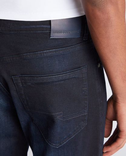 Man wearing a navy Rogan Straight Leg Eco Cotton-Stretch Jeans