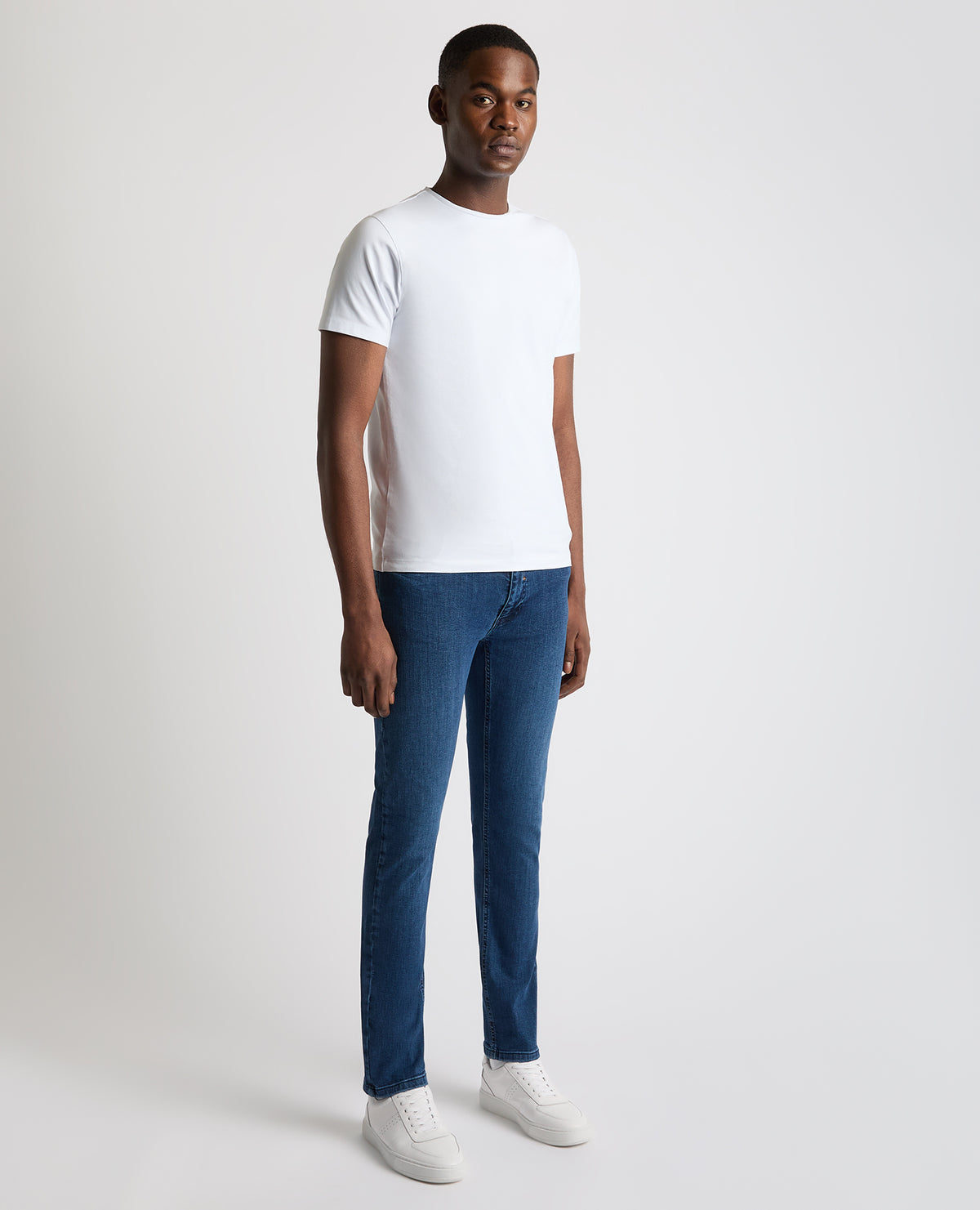 Man wearing a blue Apollo Slim Leg Cotton Stretch Jean