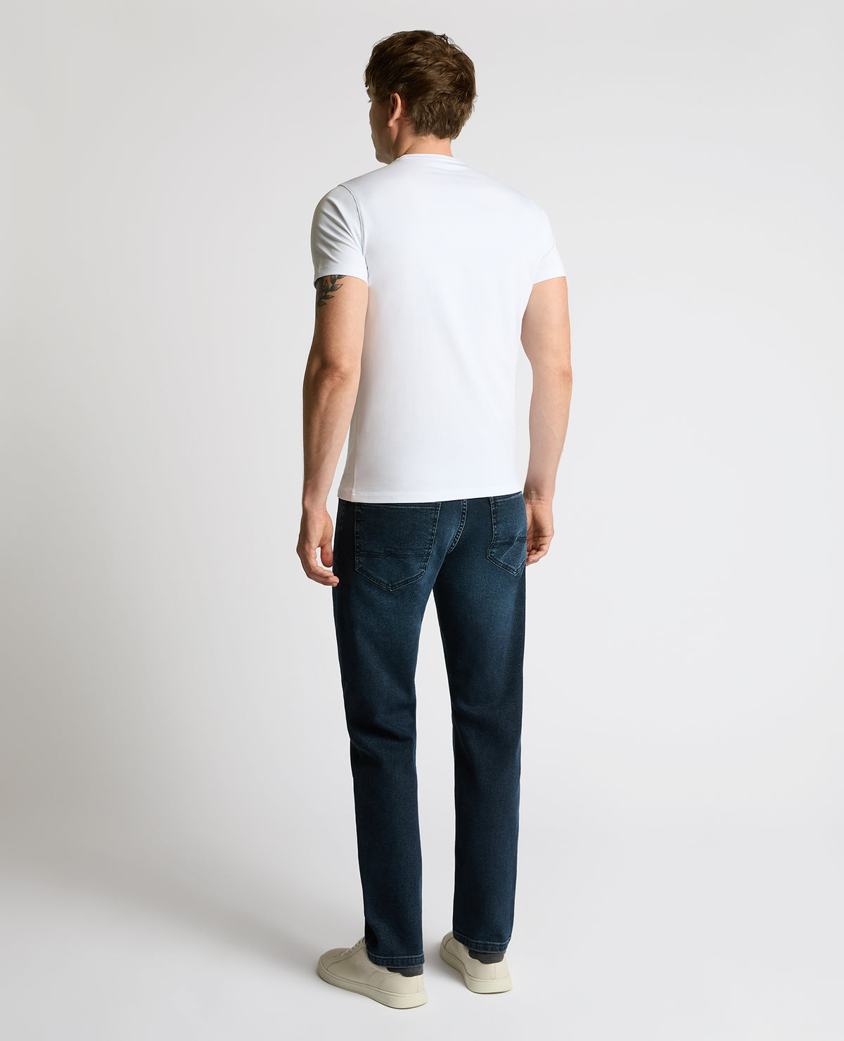 Man wearing a navy Rogan Straight Leg Jeans