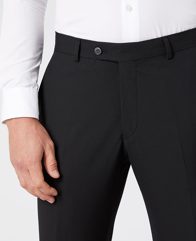 Man wearing a black Tapered Leg Stretch Formal Trousers .