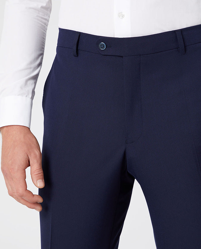 Man wearing a navy Tapered Leg Stretch Formal Trousers .
